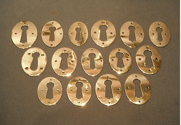 Many Similar Pressed Brass Keyhole Surrounds — Brass, circa 1900